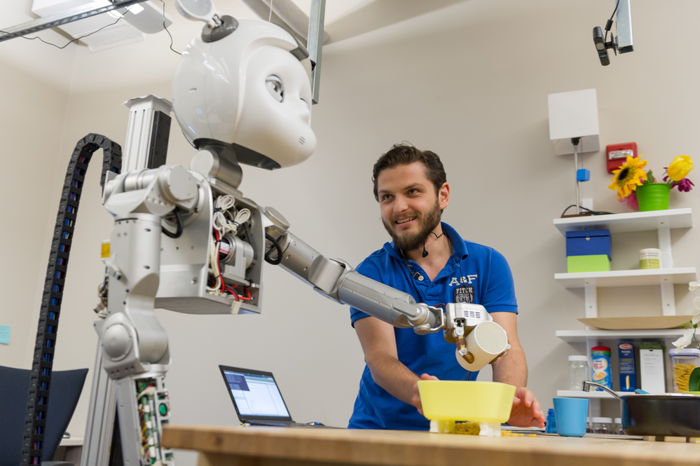 researcher workign on robot arm in lab setting.