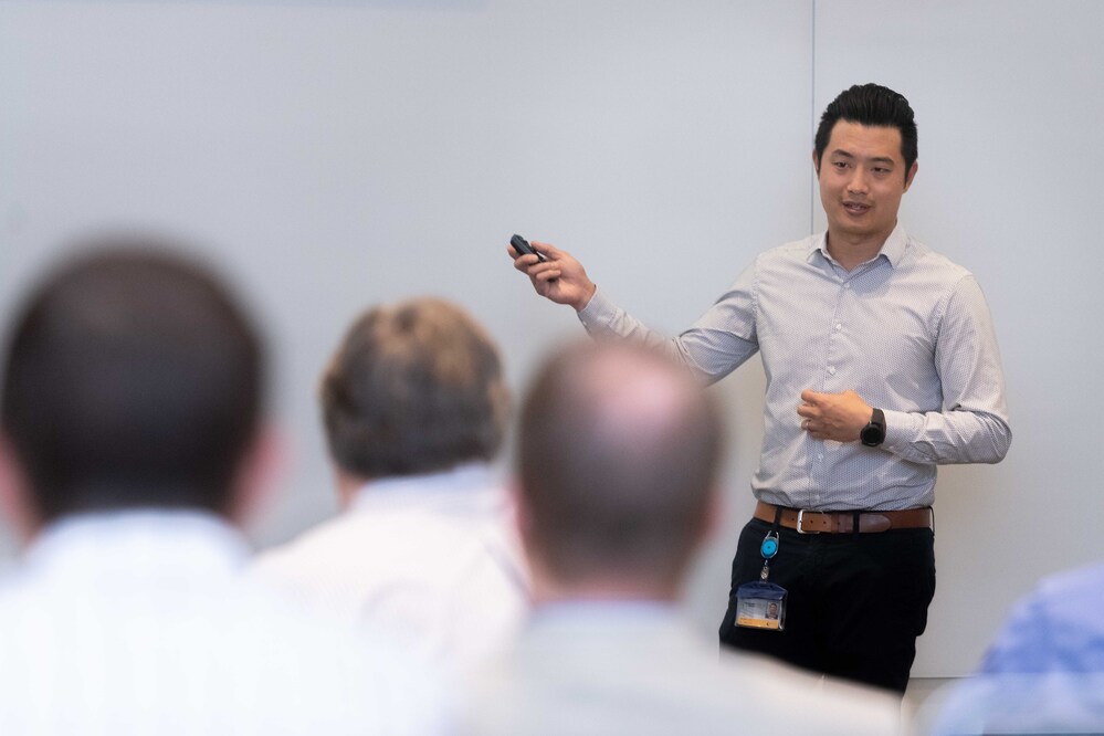 Man stands in front of giant white board teaching
