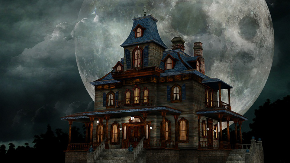 Victorian-style house with illuminated windows stands beneath a large full moon and dark, cloudy night sky.