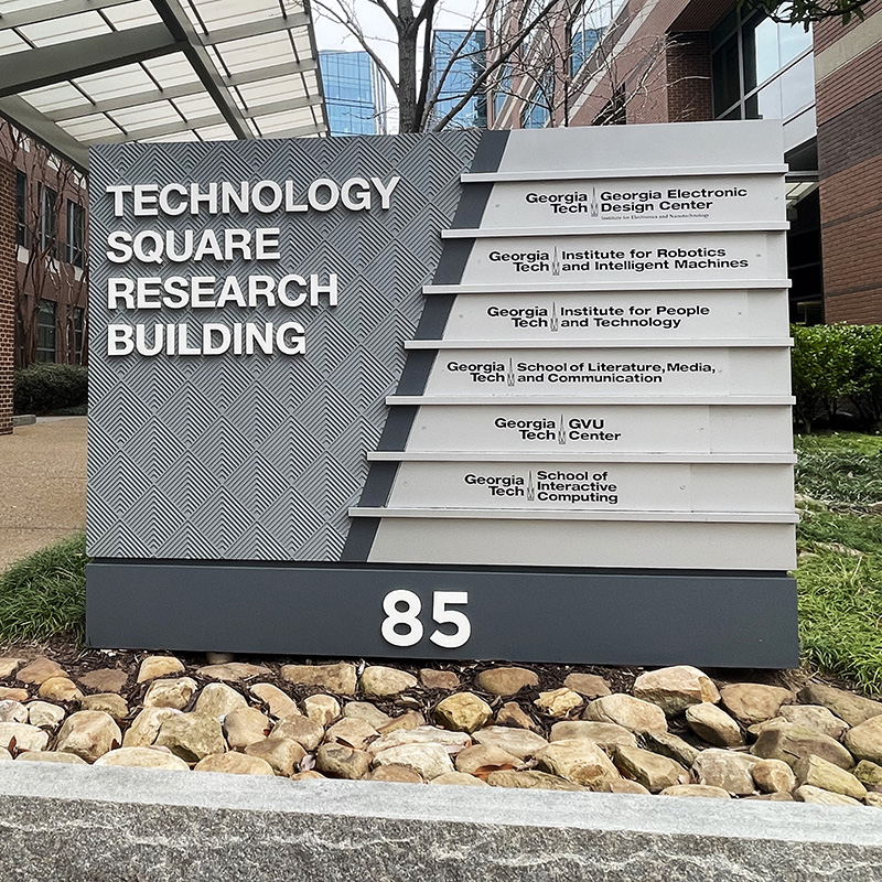 Sign for Technology Square Research Building at Georgia Tech listing departments and address number 85, with campus buildings.