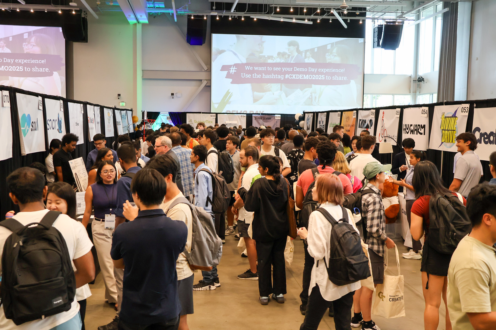 crowd of students in an antrium for a poster presentation