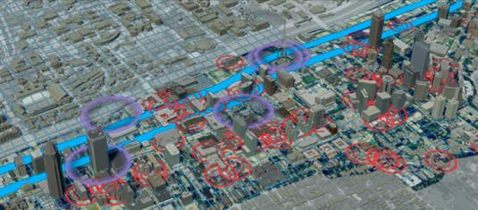 3D city model with overlaid GIS data, highlighting transportation corridors, buildings, and geographic analysis zones.